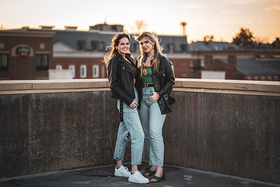 two women standing together in a city building