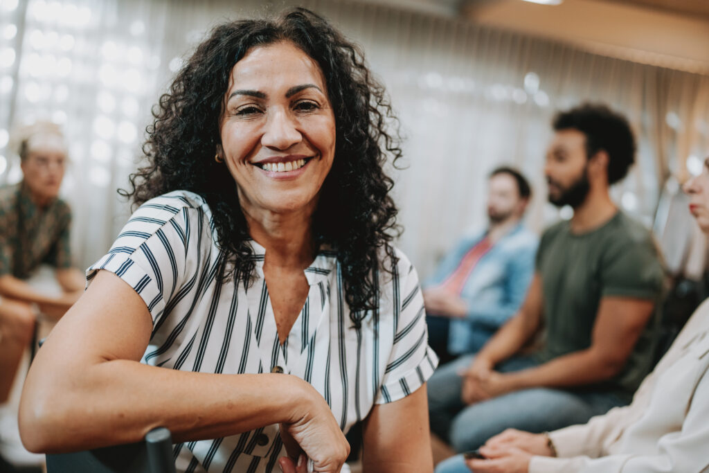 Portrait of a smiling woman in group therapy